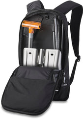 Dakine Poacher 14L on skier with diagonal ski carry engaged, demonstrating secure transport