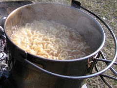 Snow Peak kettle in use over portable stove illustrating fast boiling and outdoor cooking benefit
