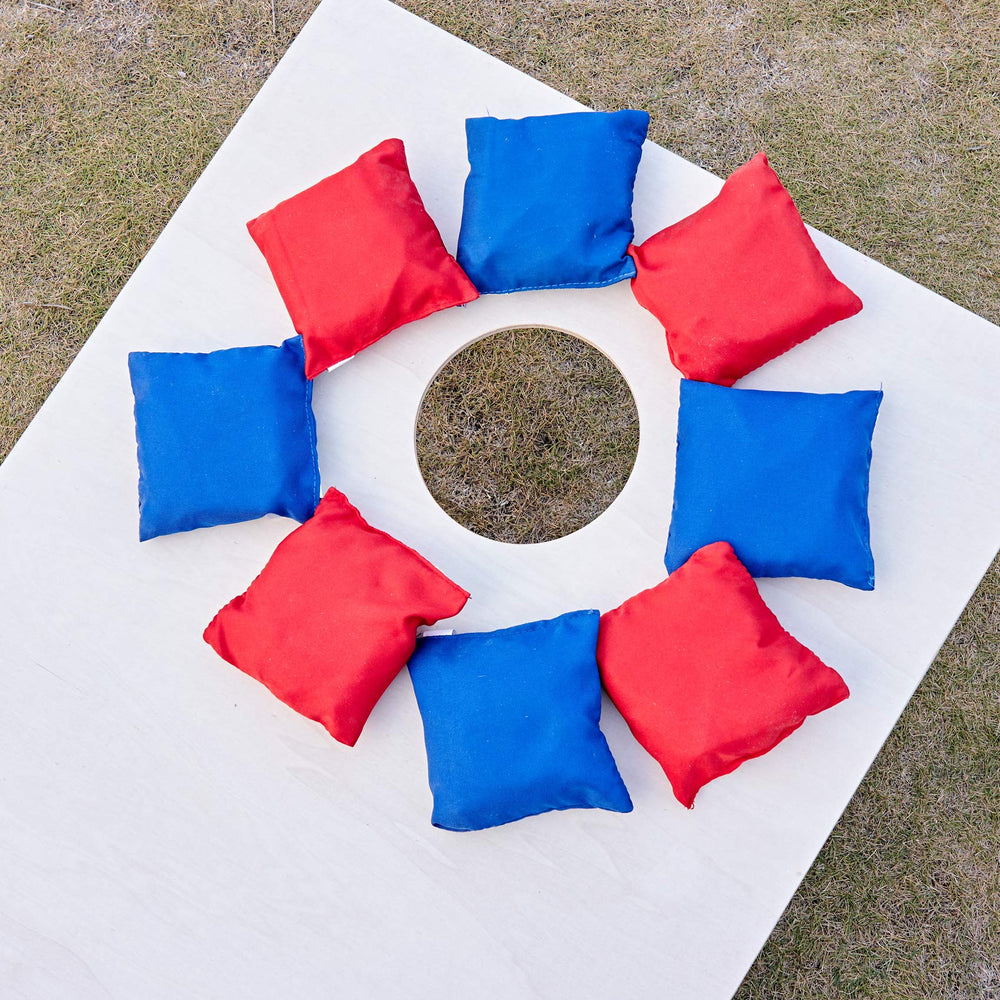 ApudArmis bags on backyard cornhole board in play showing social outdoor fun and easy setup