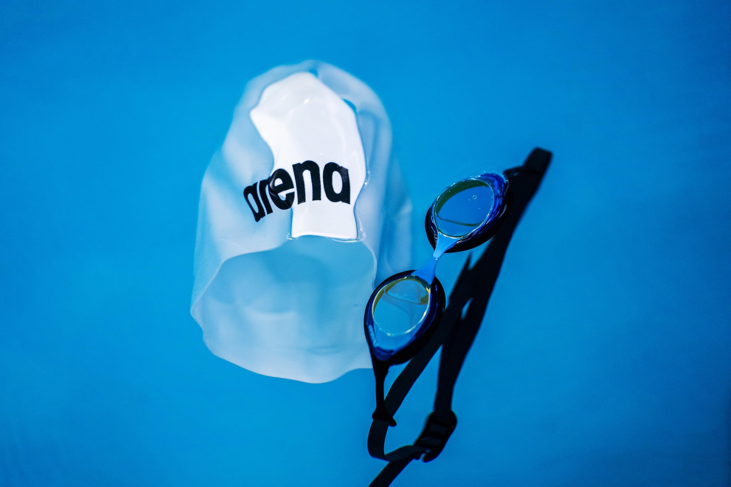 ARENA Cobra next to hand and packaging showing size and included accessories benefit