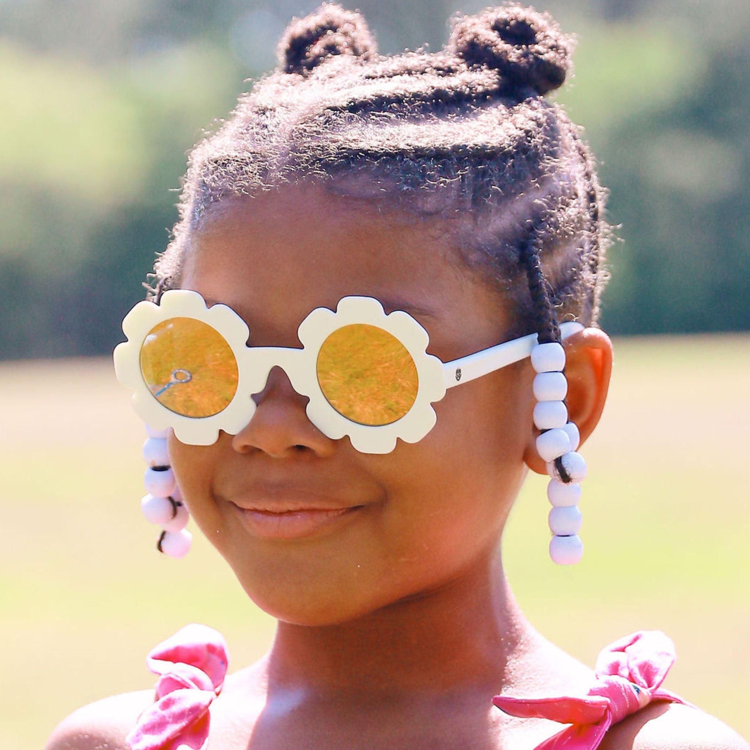 Babiators sunglasses next to a toy to show size scale for ages 0–2