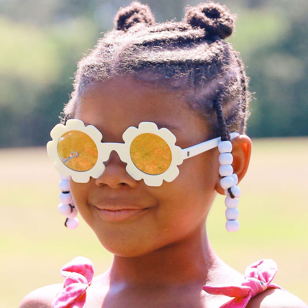 Babiators sunglasses next to a toy to show size scale for ages 0–2