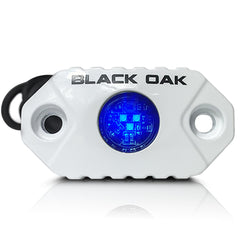 Black Oak front view puck light showing blue glow and durable housing for visibility