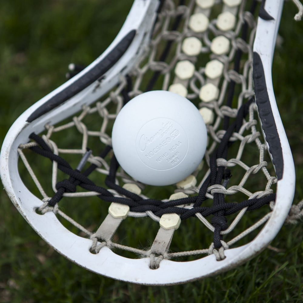 Champion Sports lacrosse ball in midair demonstrating consistent flight and low-bounce benefit
