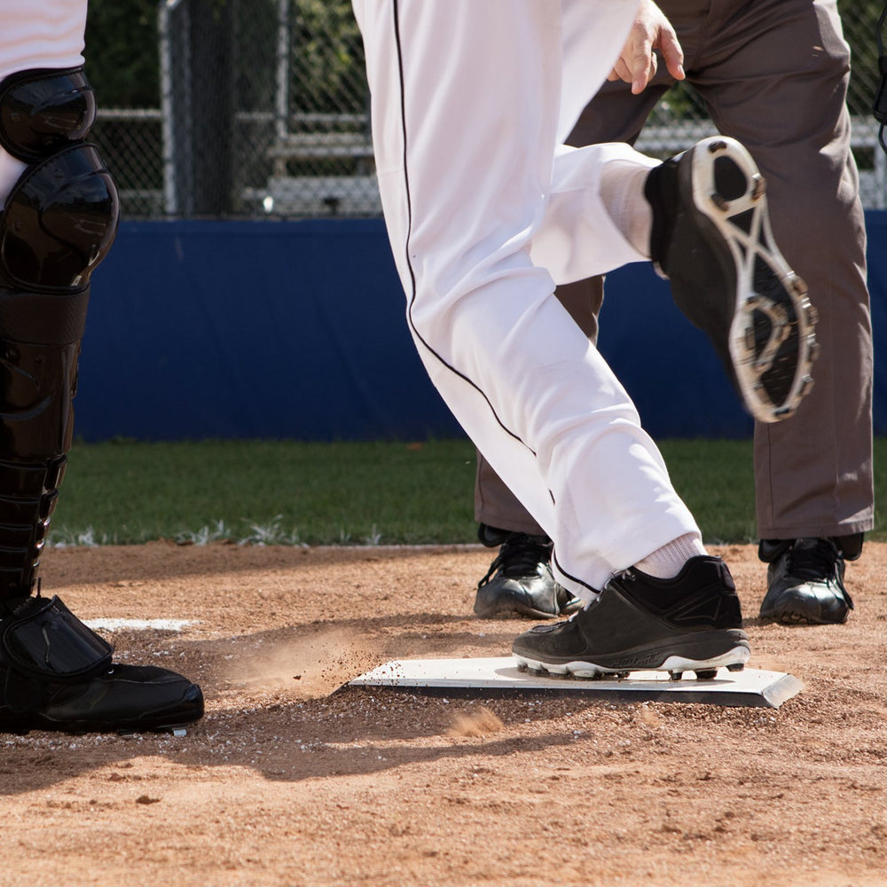 Champion Sports home plate in use with sliding player demonstrating safer, predictable contact