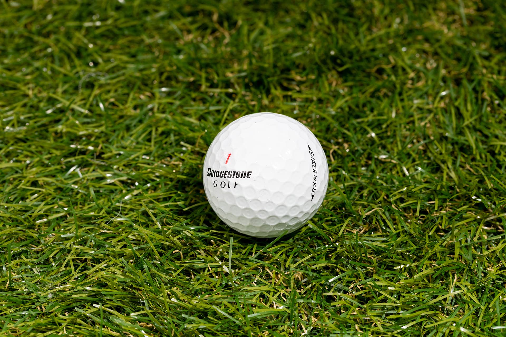 Clean Green Golf Balls beside a tee for scale demonstrating true golf-size consistency