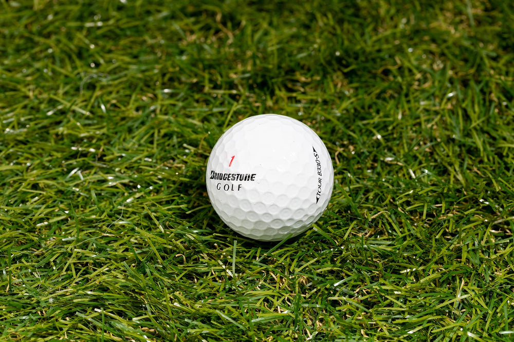 Clean Green Golf Balls beside a tee for scale demonstrating true golf-size consistency