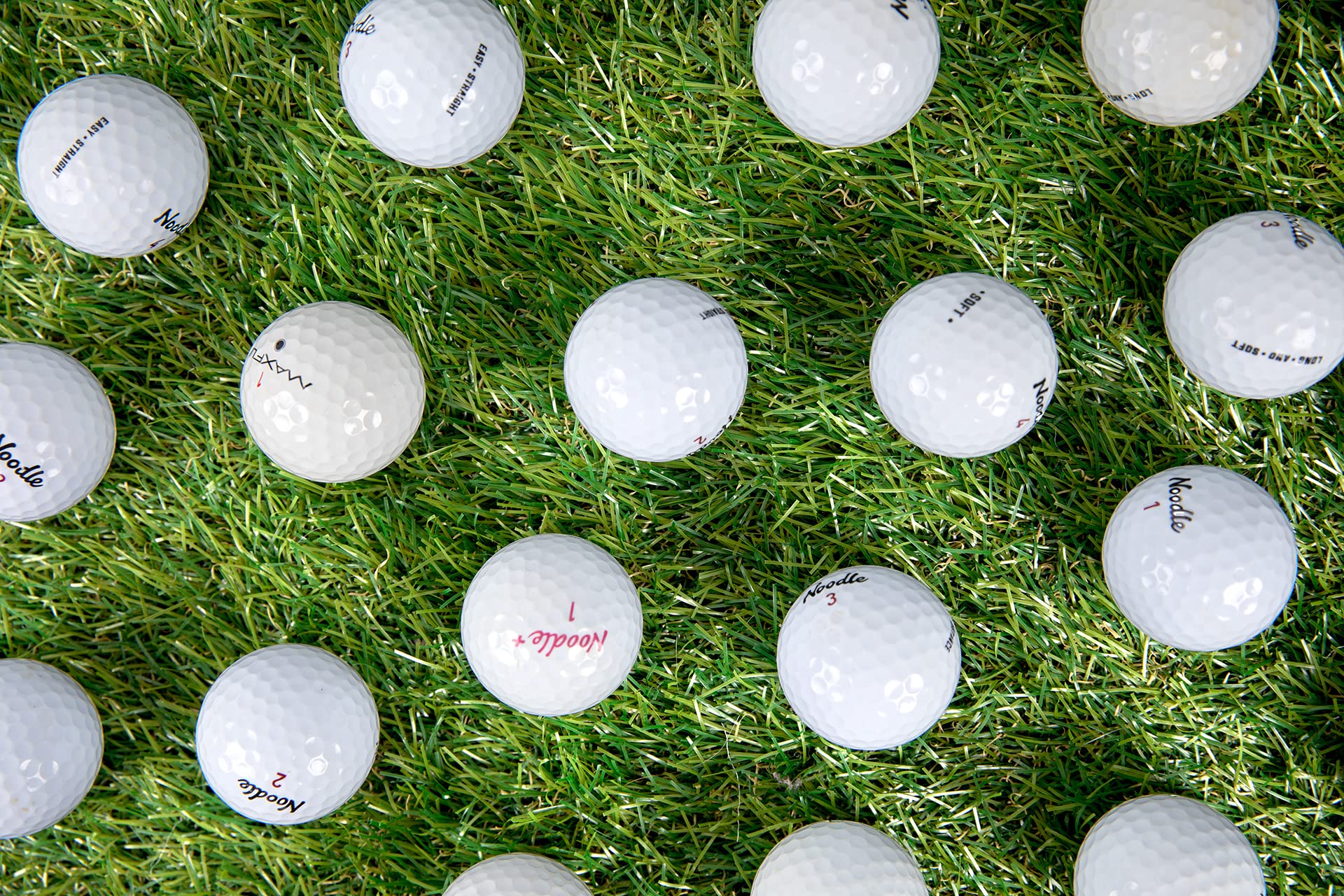 Clean Green Golf Balls spread on grass illustrating volume and variety for drills