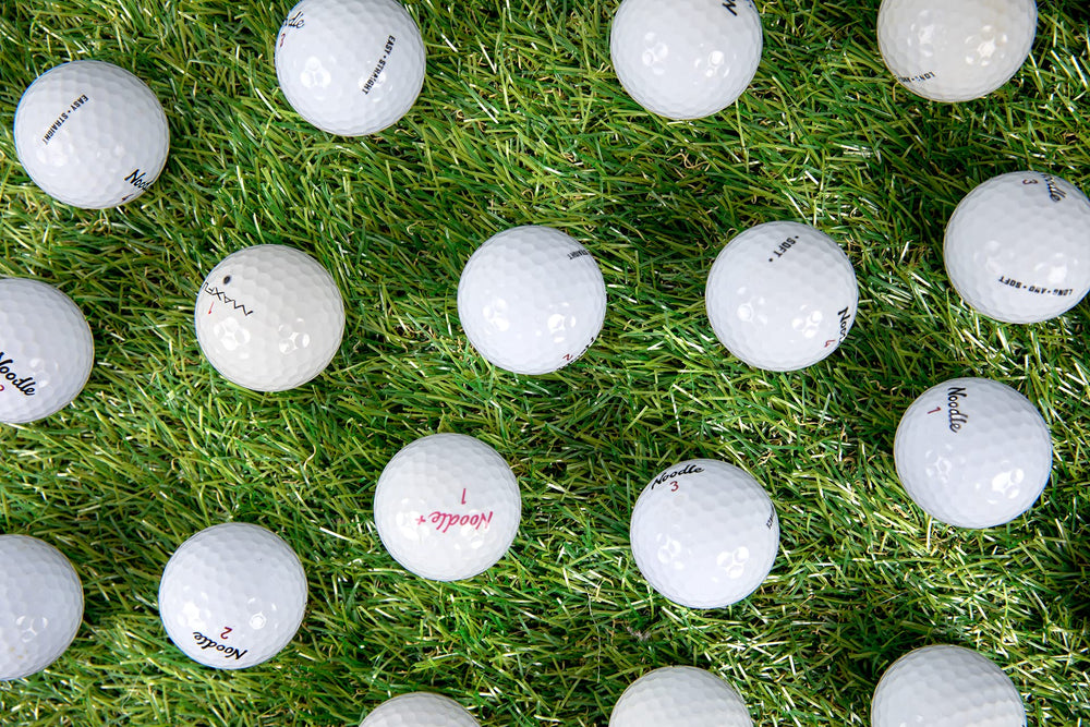 Clean Green Golf Balls spread on grass illustrating volume and variety for drills