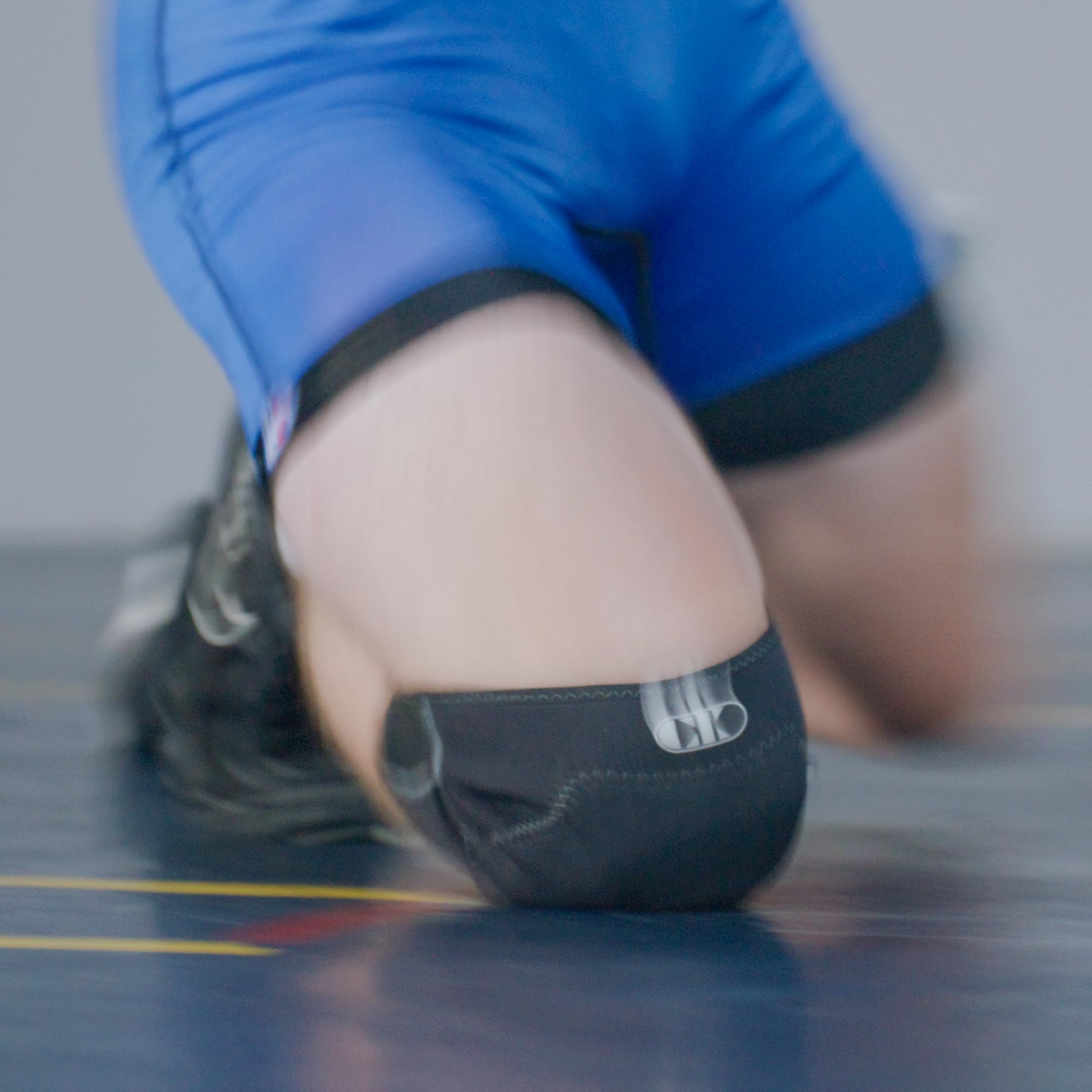Cliff Keen knee pad beside a measuring tape showing compact size and scale