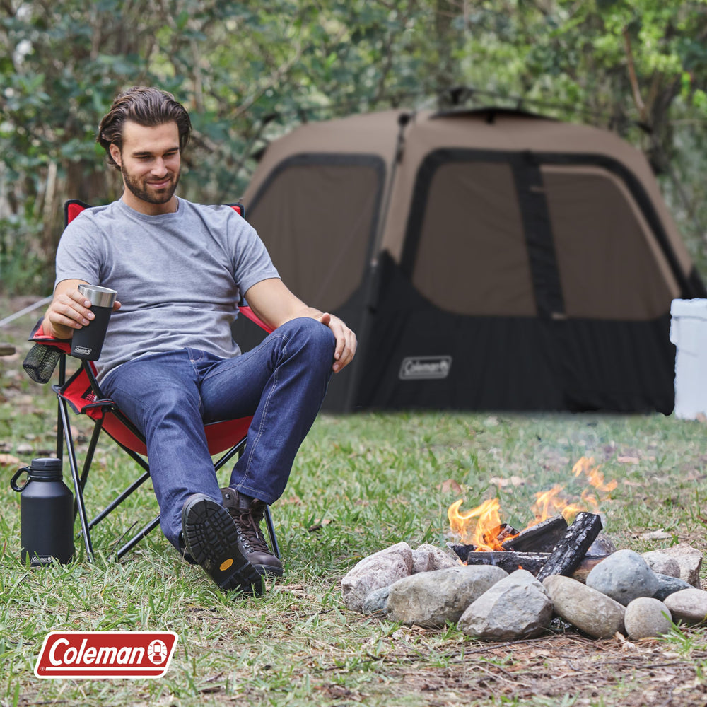 Coleman tent at campsite near campfire illustrating easy setup and outdoor comfort