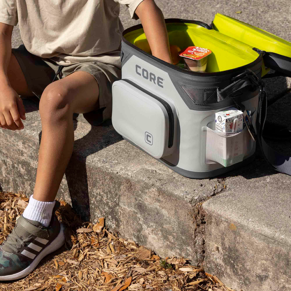 CORE cooler on a beach towel with snacks to illustrate picnic-ready convenience