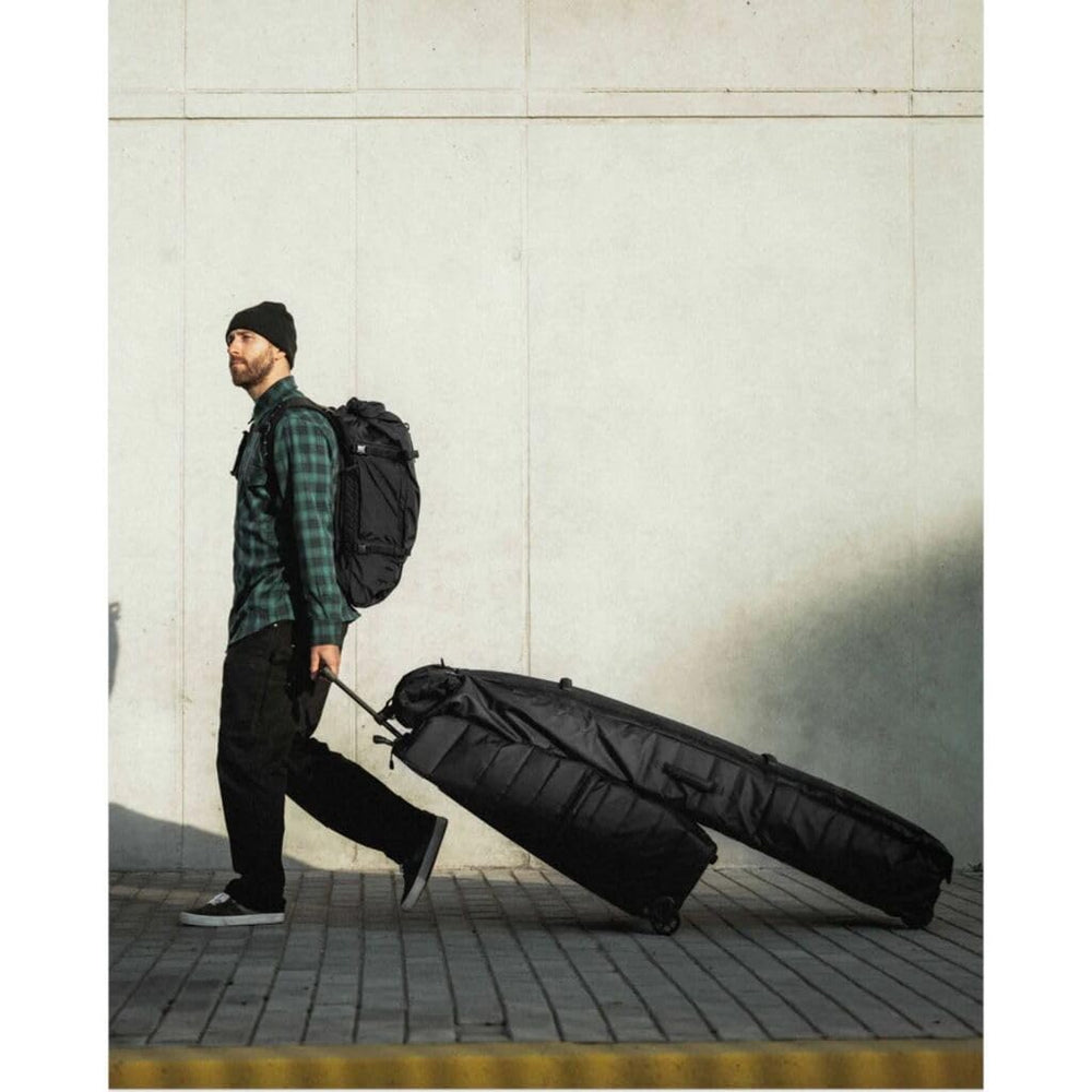 Db Journey Snow Roller Pro in airport with skier carrying bag, convenient travel solution