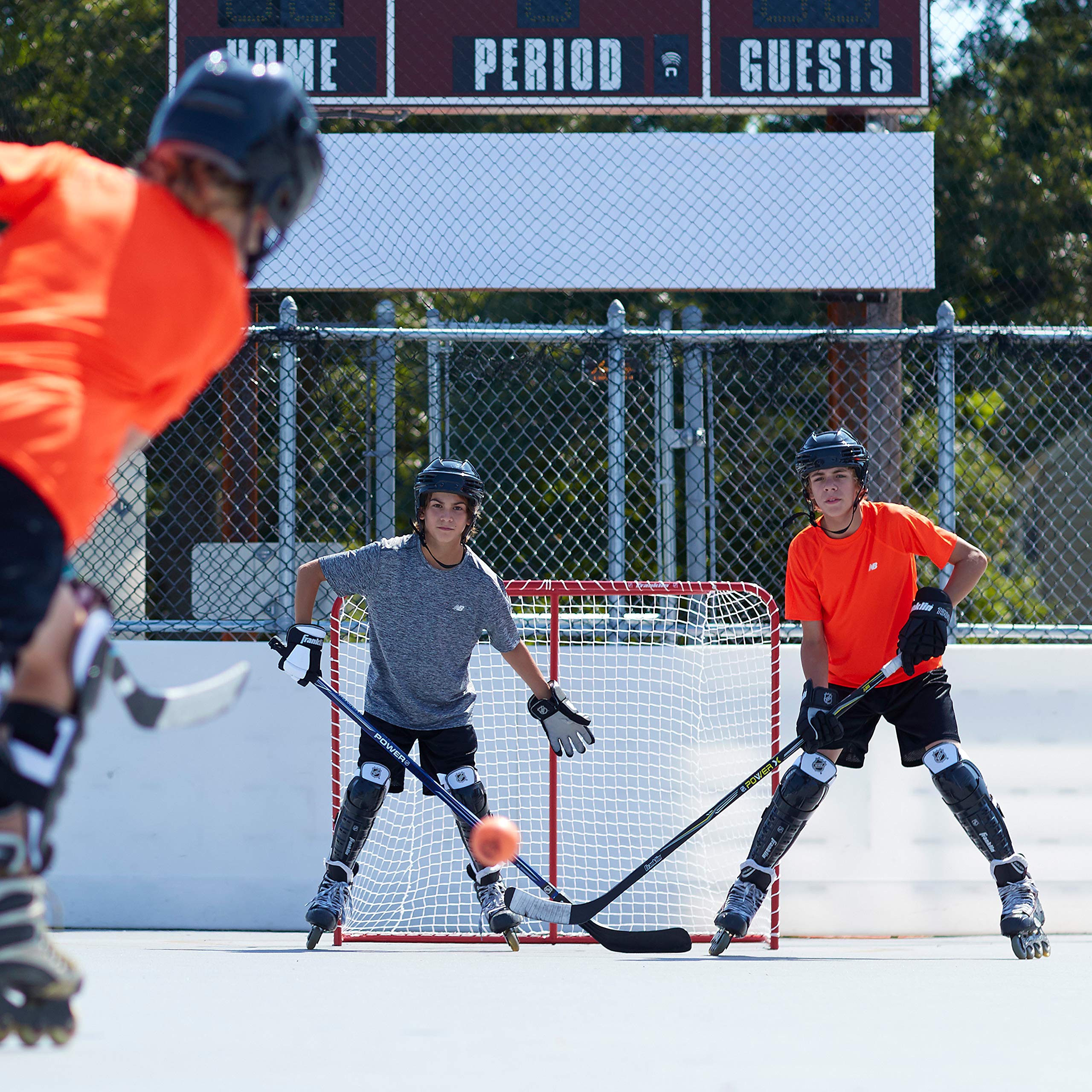 Franklin Sports next to hockey stick for scale showing compact youth-sized dimensions