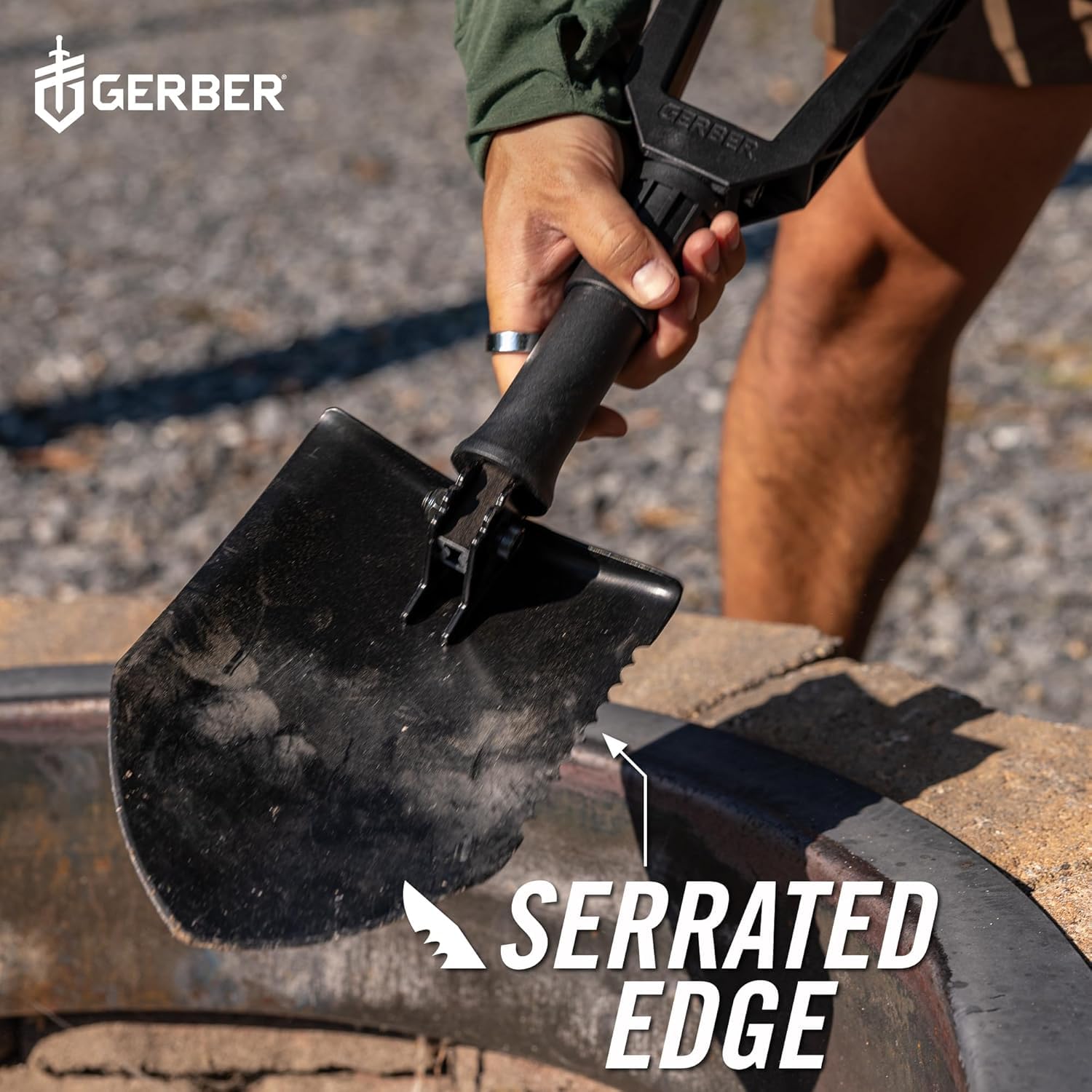 Gerber E-Tool next to a hand for scale to illustrate compact size and transport convenience benefit