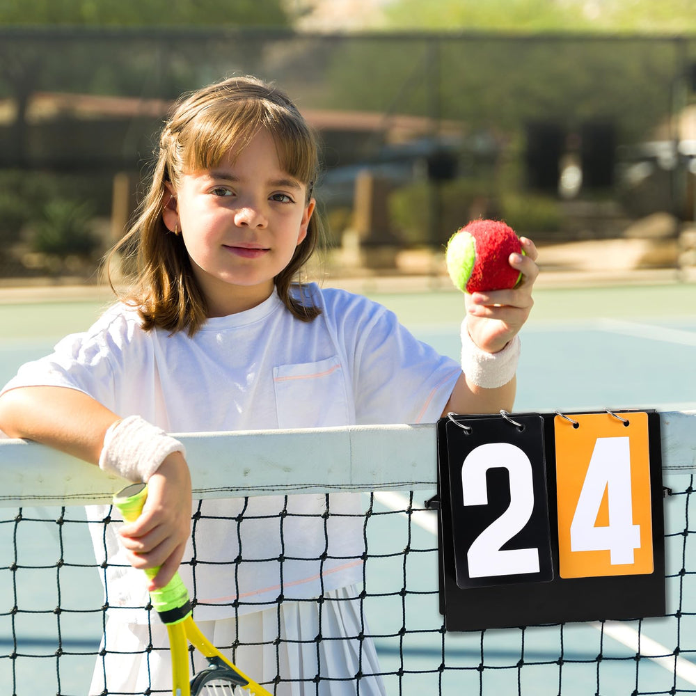 Hiboom scoreboard beside a tennis ball for scale showing compact portability and court-ready size
