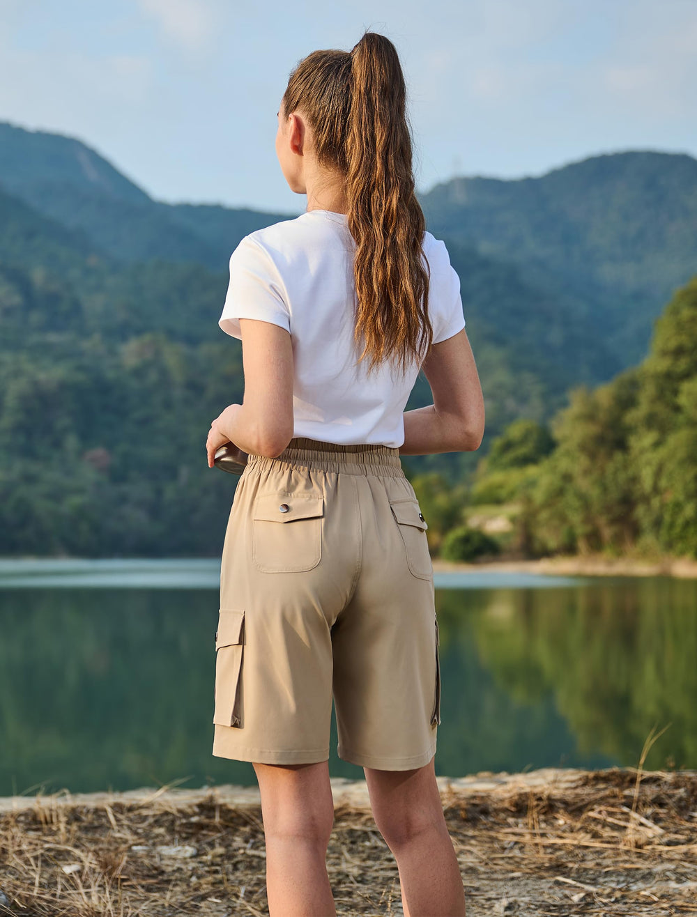 Hugut shorts on model next to a water bottle showing scale and coverage benefit