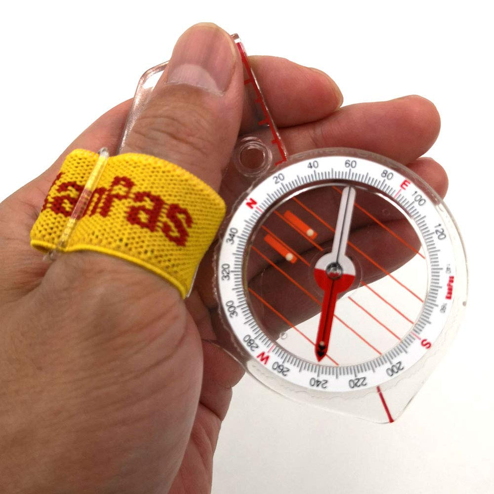 KanPas thumb-mounted compass in use on map for hands-free navigation