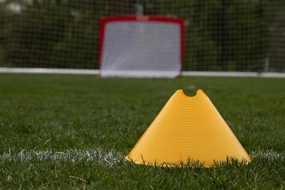 Kwik Goal cone paired with coaching stick forming low hurdle for varied training