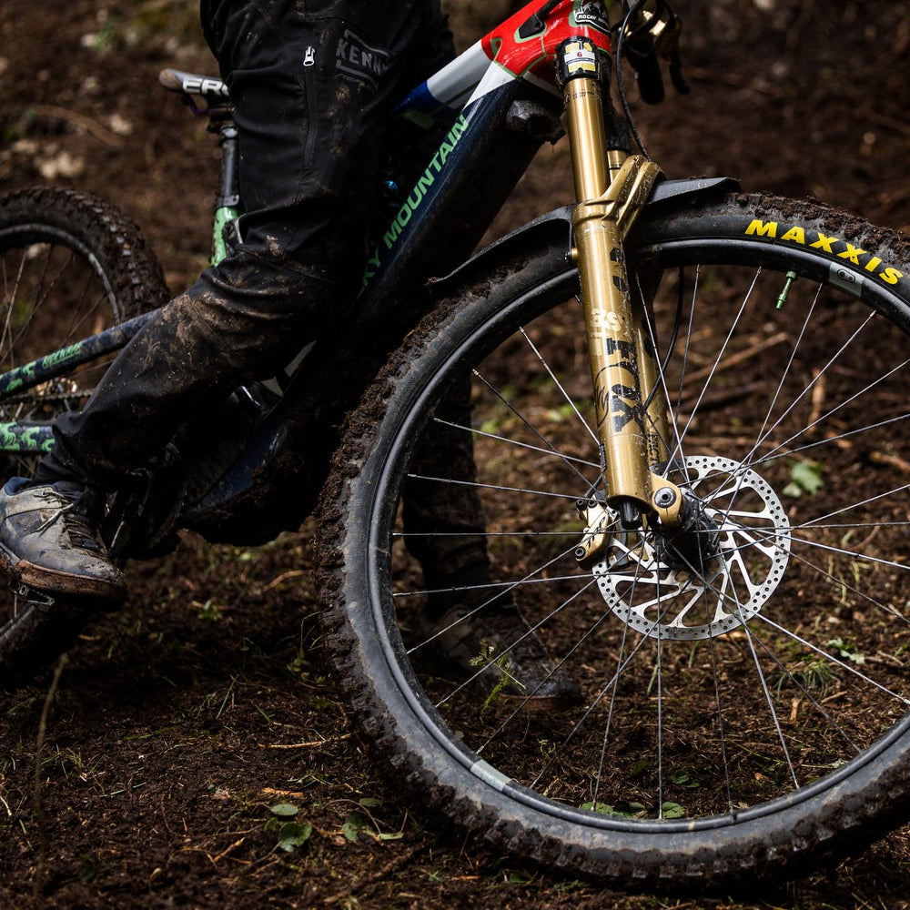 MAXXIS tire rolling through mud demonstrating self-cleaning and traction
