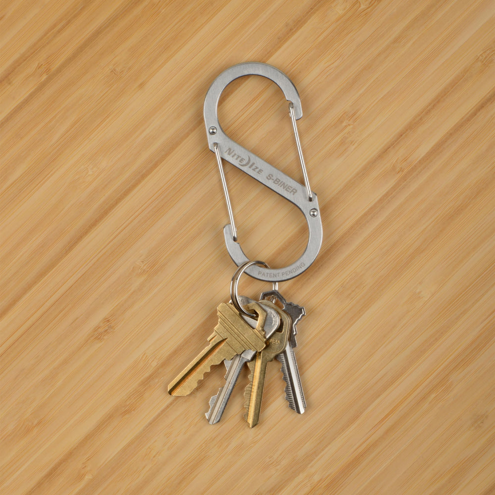 Nite Ize clip fastened to backpack strap showing reliable gear attachment on trail