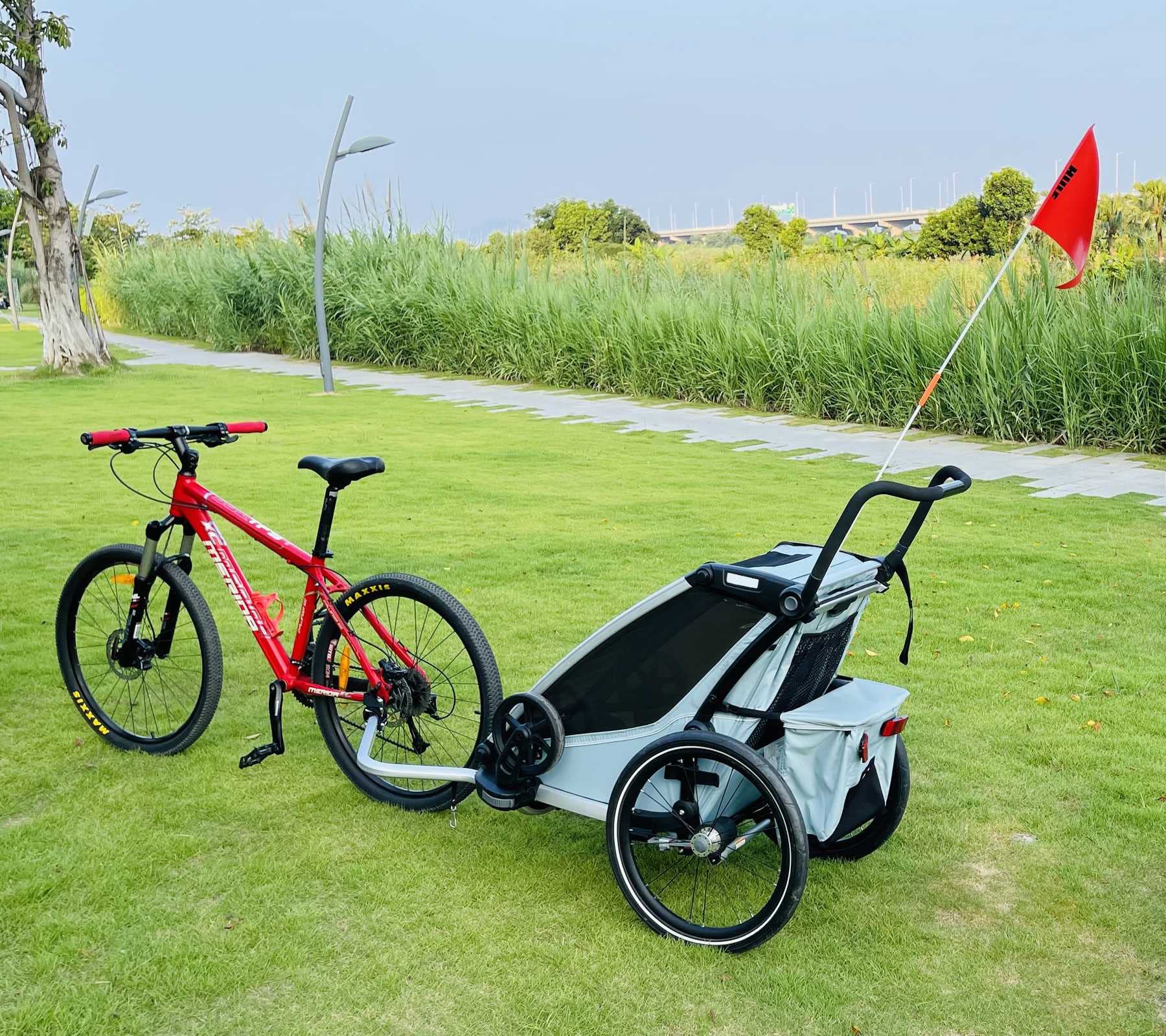 ODIER lifestyle scene of bike towing Thule trailer showing easy multi-user towing