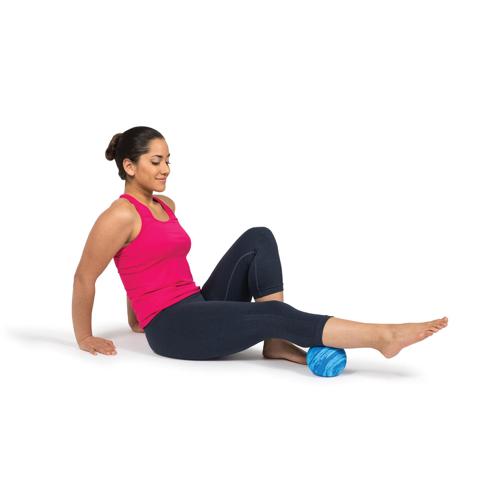 OPTP PRO Soft Release Ball on gym mat next to equipment, recovery tool for workouts