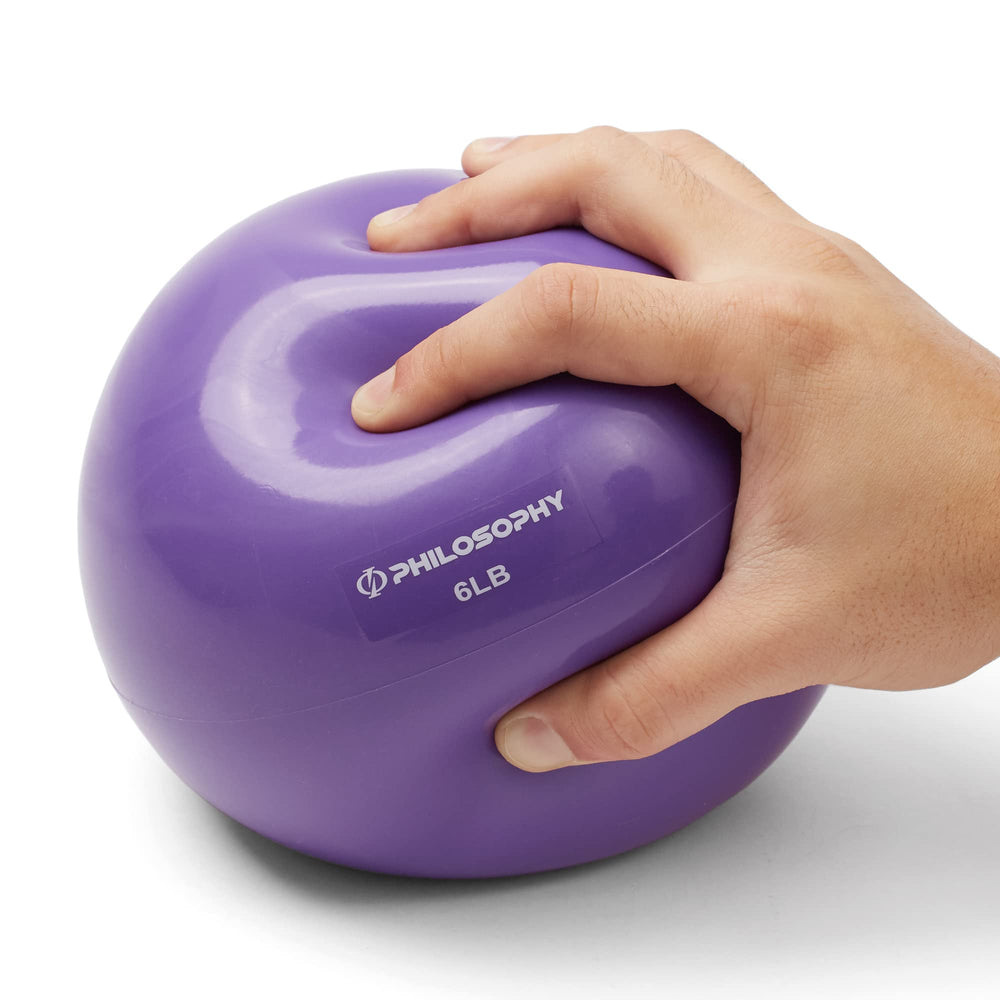 Philosophy Gym 6 lb ball held in hand to show scale and easy maneuverability for exercises