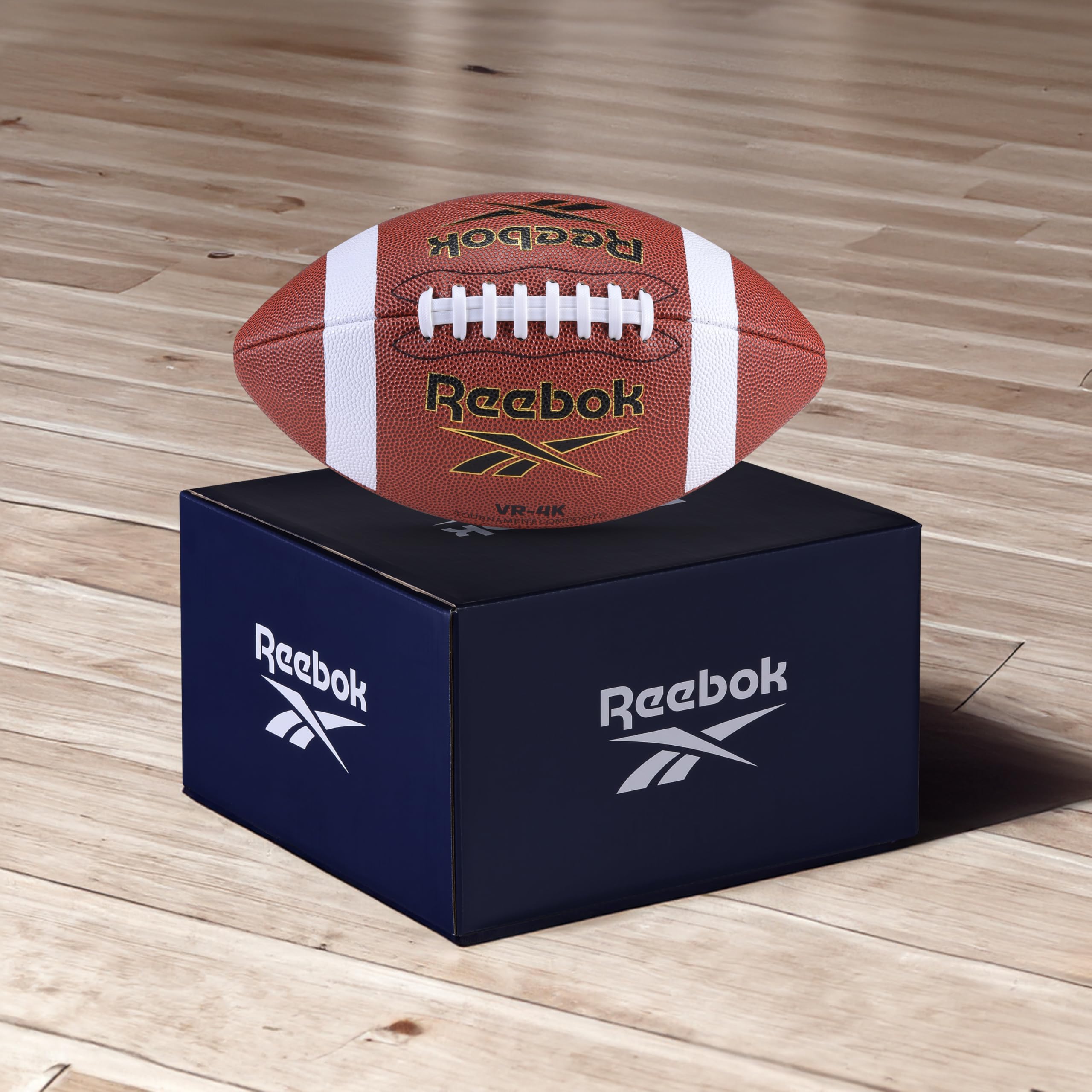 Reebok football held in adult hand showing official size and scale advantage