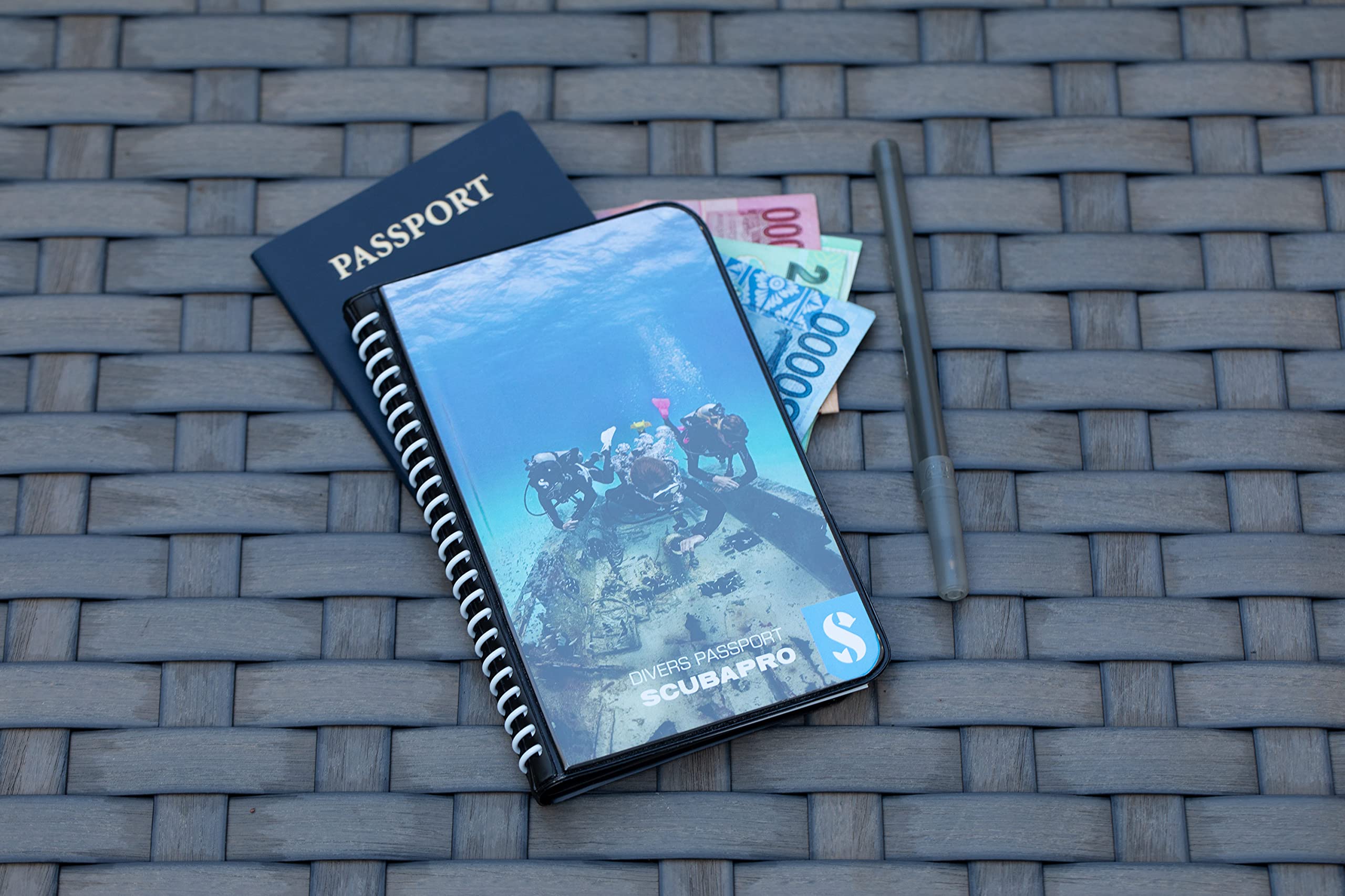 SCUBAPRO logbook next to dive mask and regulator showing compact portability benefit