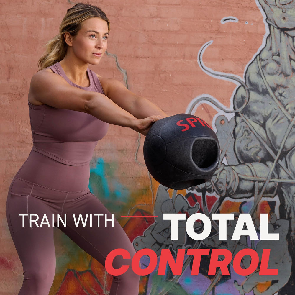 SPRI ball next to a dumbbell showing compact size and easy storage advantage
