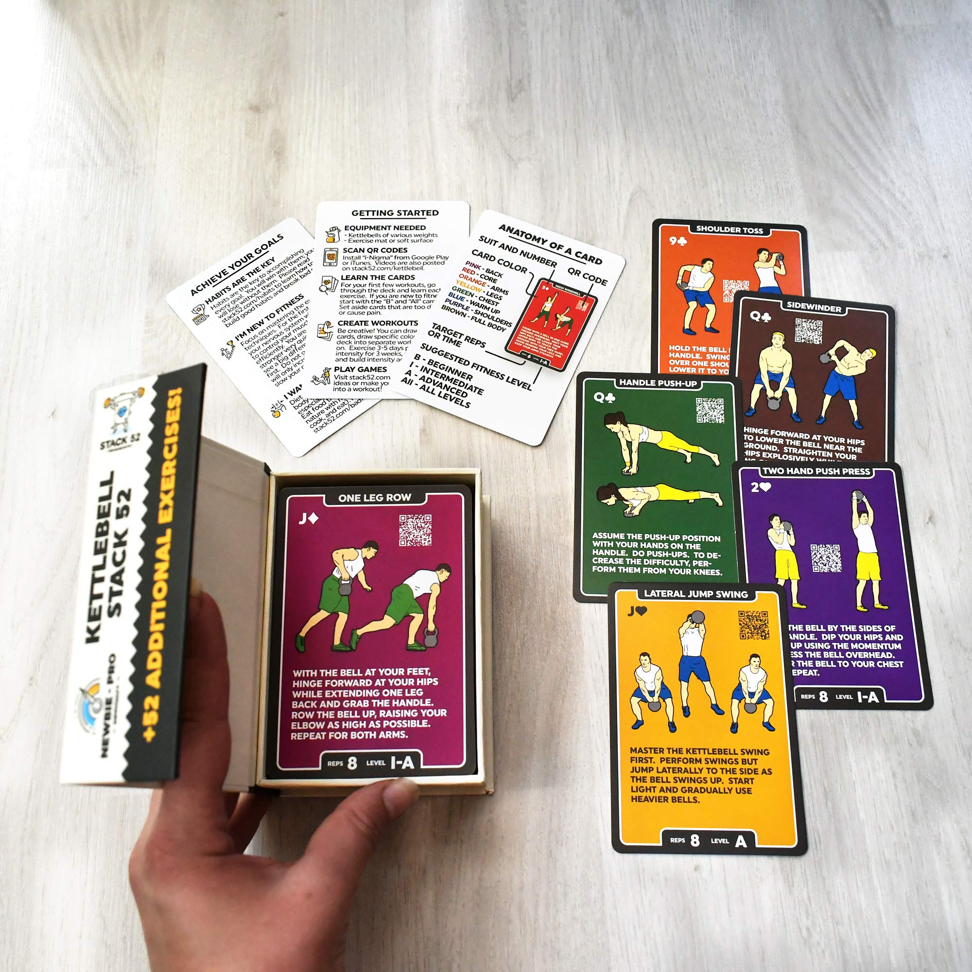 Hand holding a Stack 52 card to show portable size and easy workout planning