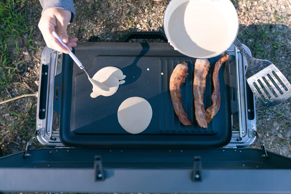 Stansport griddle next to utensils to show 18-inch size and packing convenience