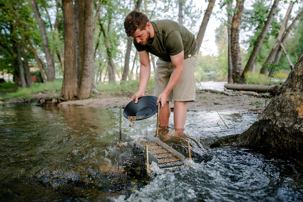 Stansport pans in use at a stream demonstrating field panning steps