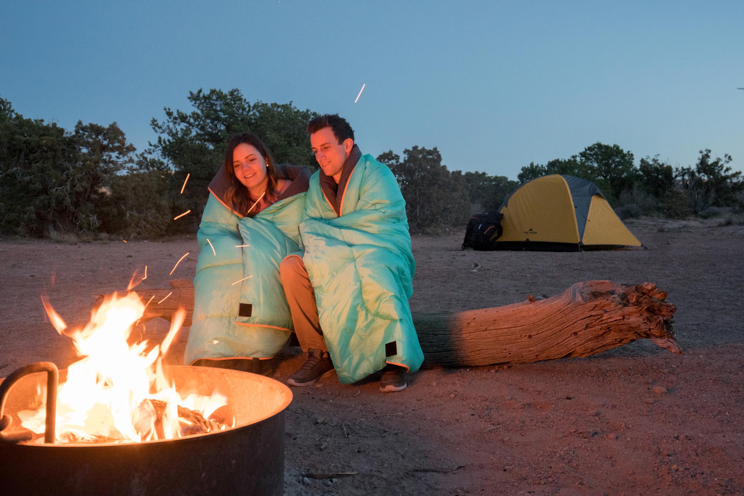 TETON Sports sleeping bag in included stuff sack beside backpack showing travel scale
