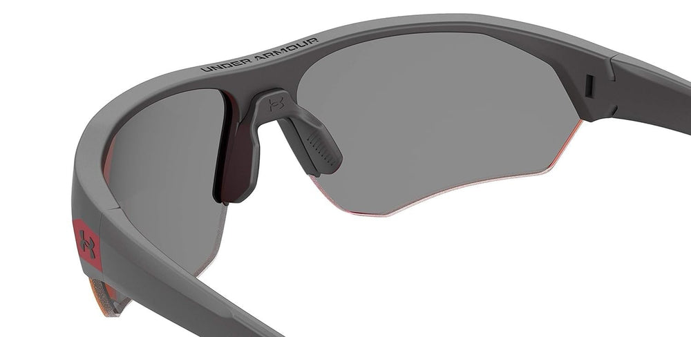 Under Armour sunglasses beside ruler showing 69mm lens sizing for proper fit benefit