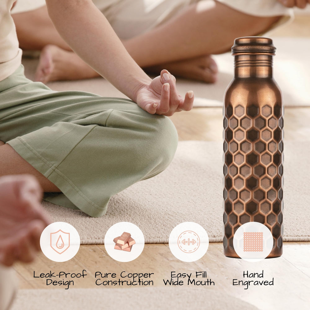 Velantic Copper next to a water glass showing 32 oz capacity for long hydration