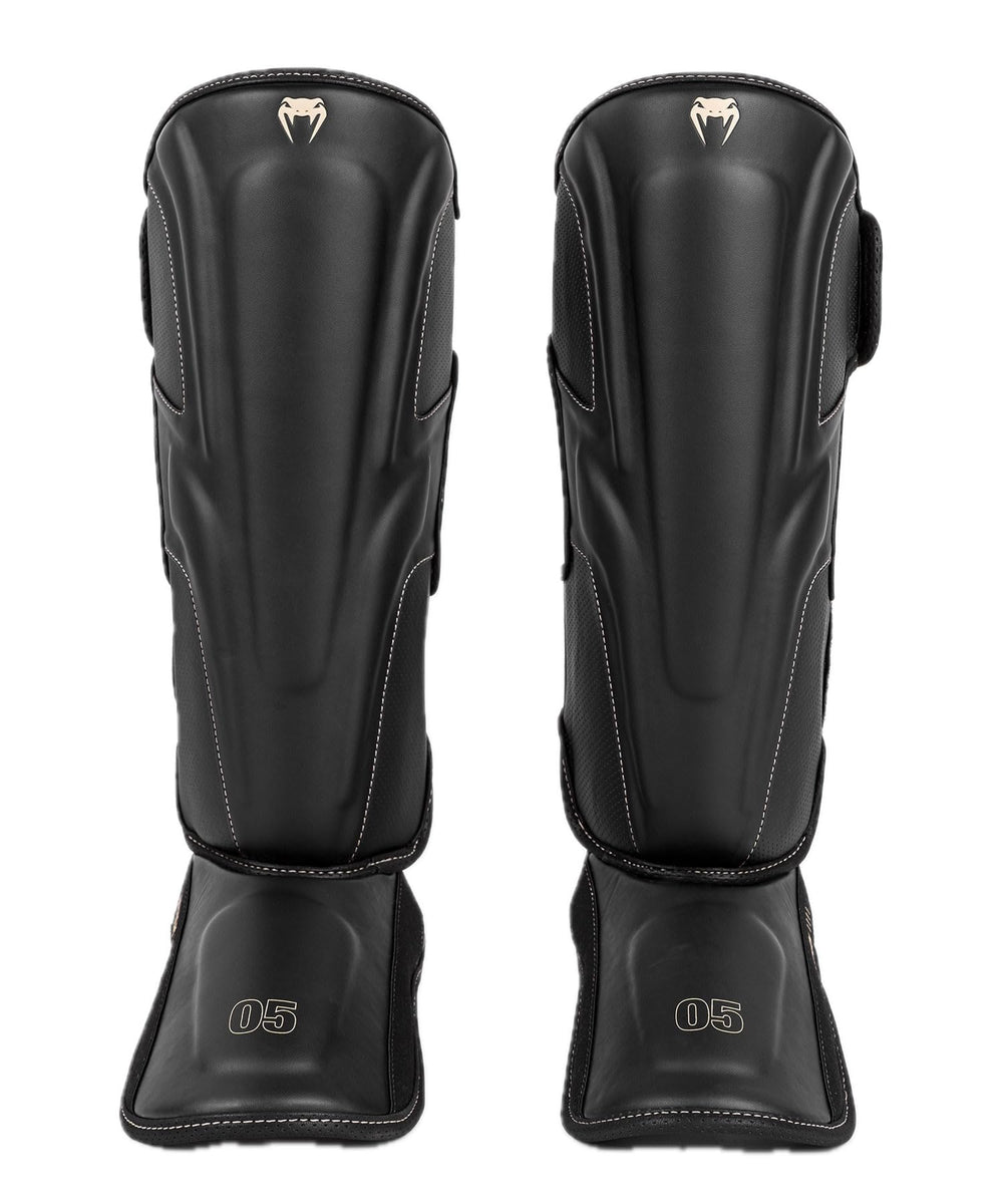 Venum Impact Evo front view showing black shin guard and beige stitching for confidence