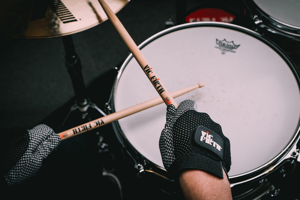 Vic Firth glove size scale with drumstick for accurate small fit and proportion reference