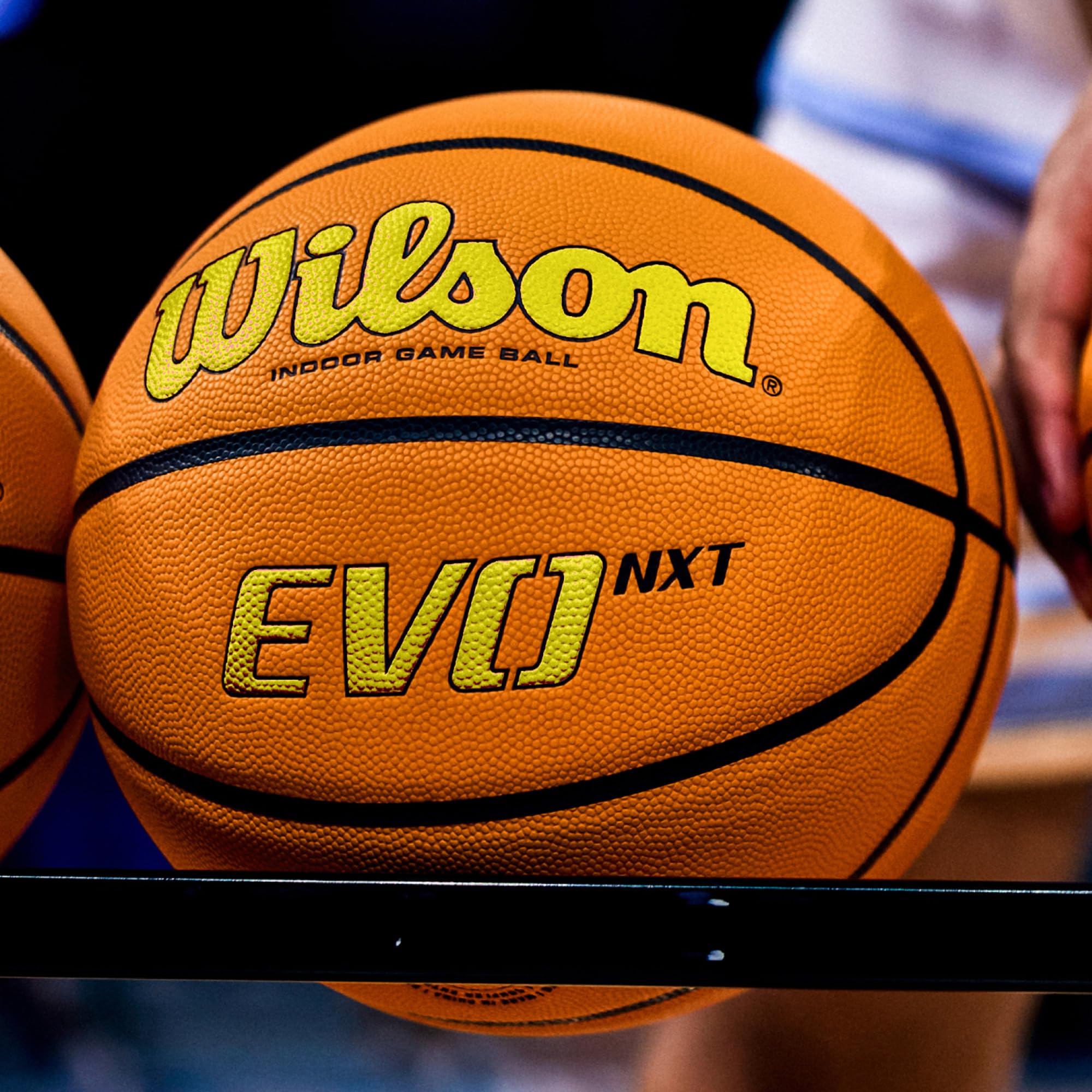 WILSON Evo NXT on wooden gym floor in lifestyle shot showing professional indoor game readiness