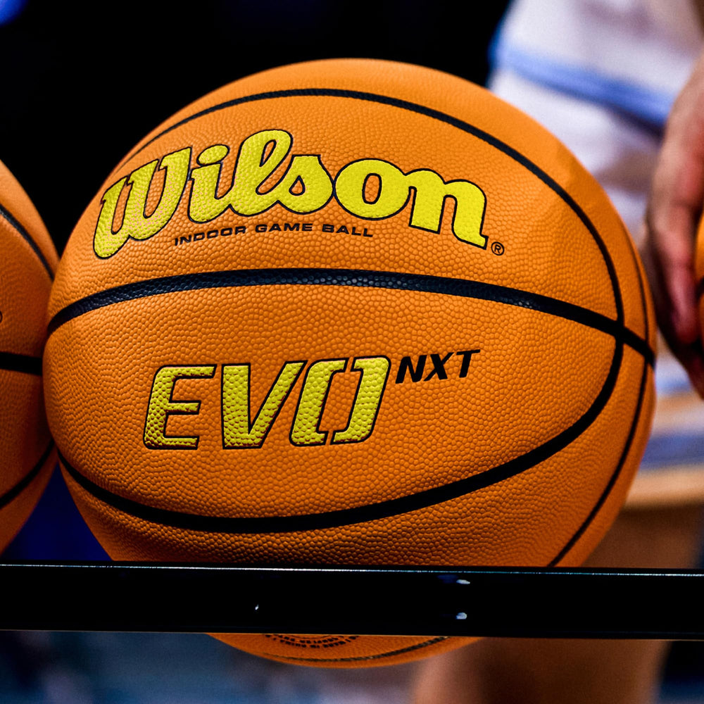 WILSON Evo NXT on wooden gym floor in lifestyle shot showing professional indoor game readiness