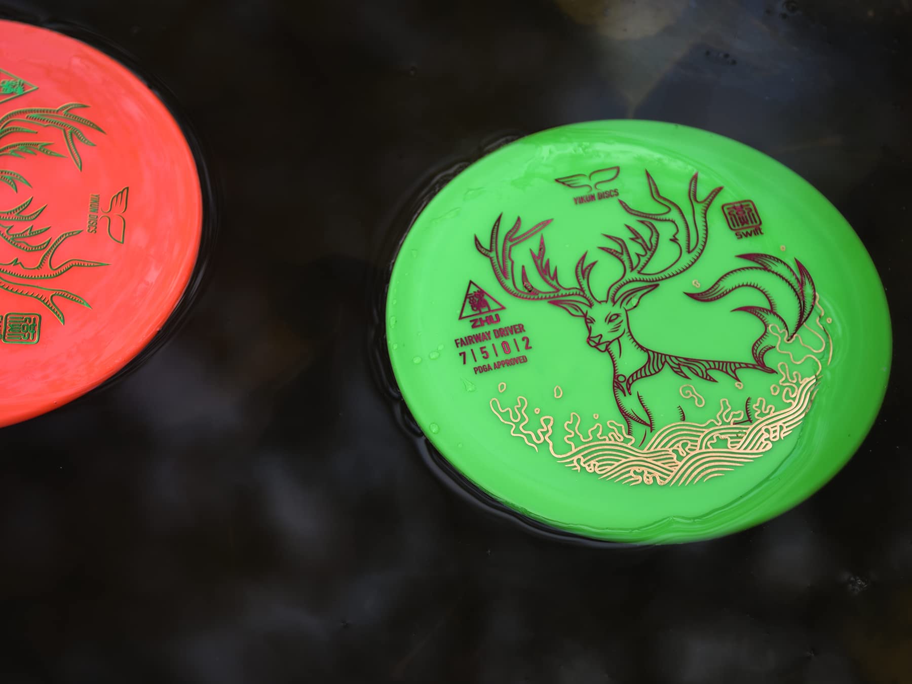 yikundiscs in mid-throw on a course by water, showcasing controlled distance and accuracy