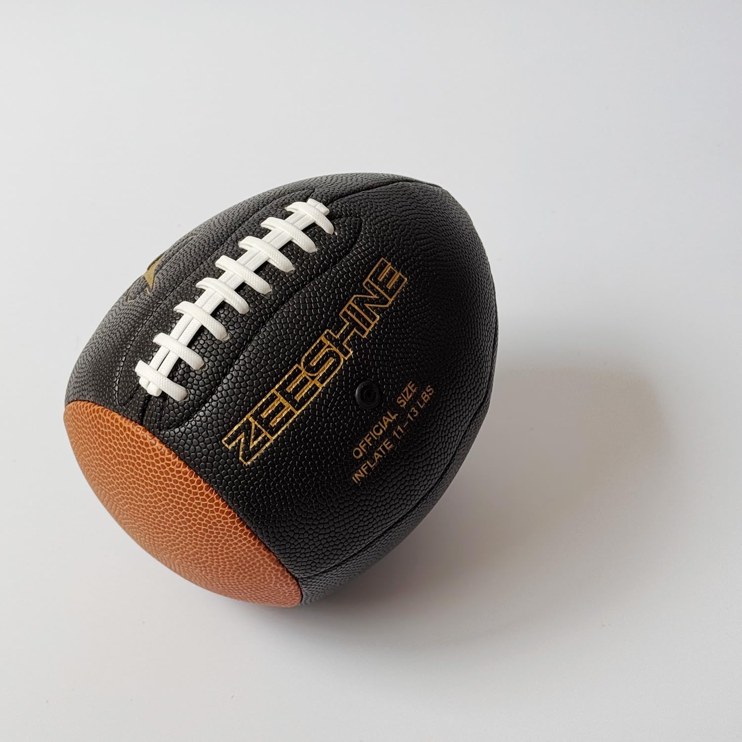 ZEESHINE football next to hand for scale to show compact training size